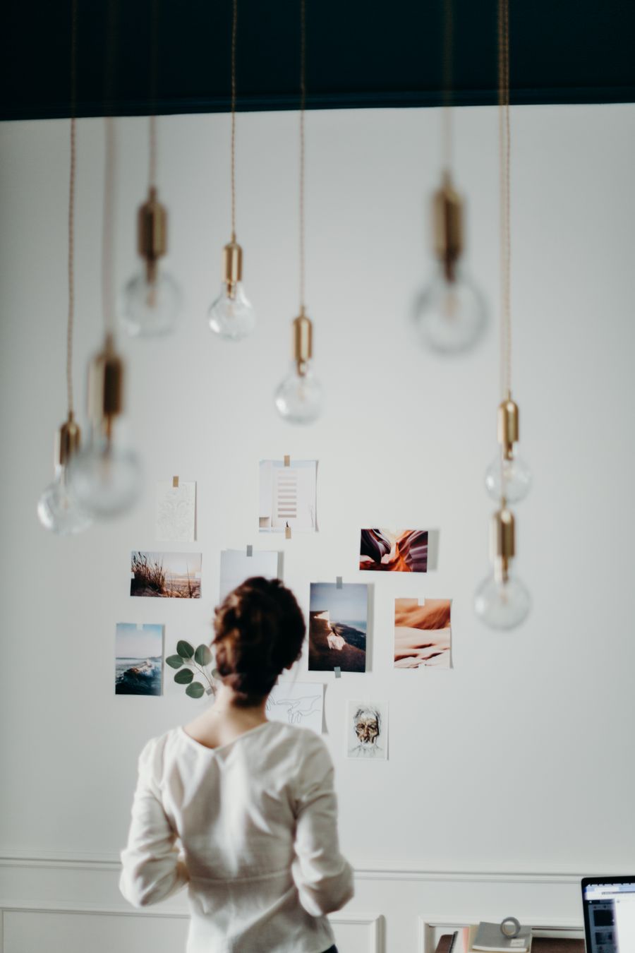 Designer studying a moodboard wall of pinned reference images